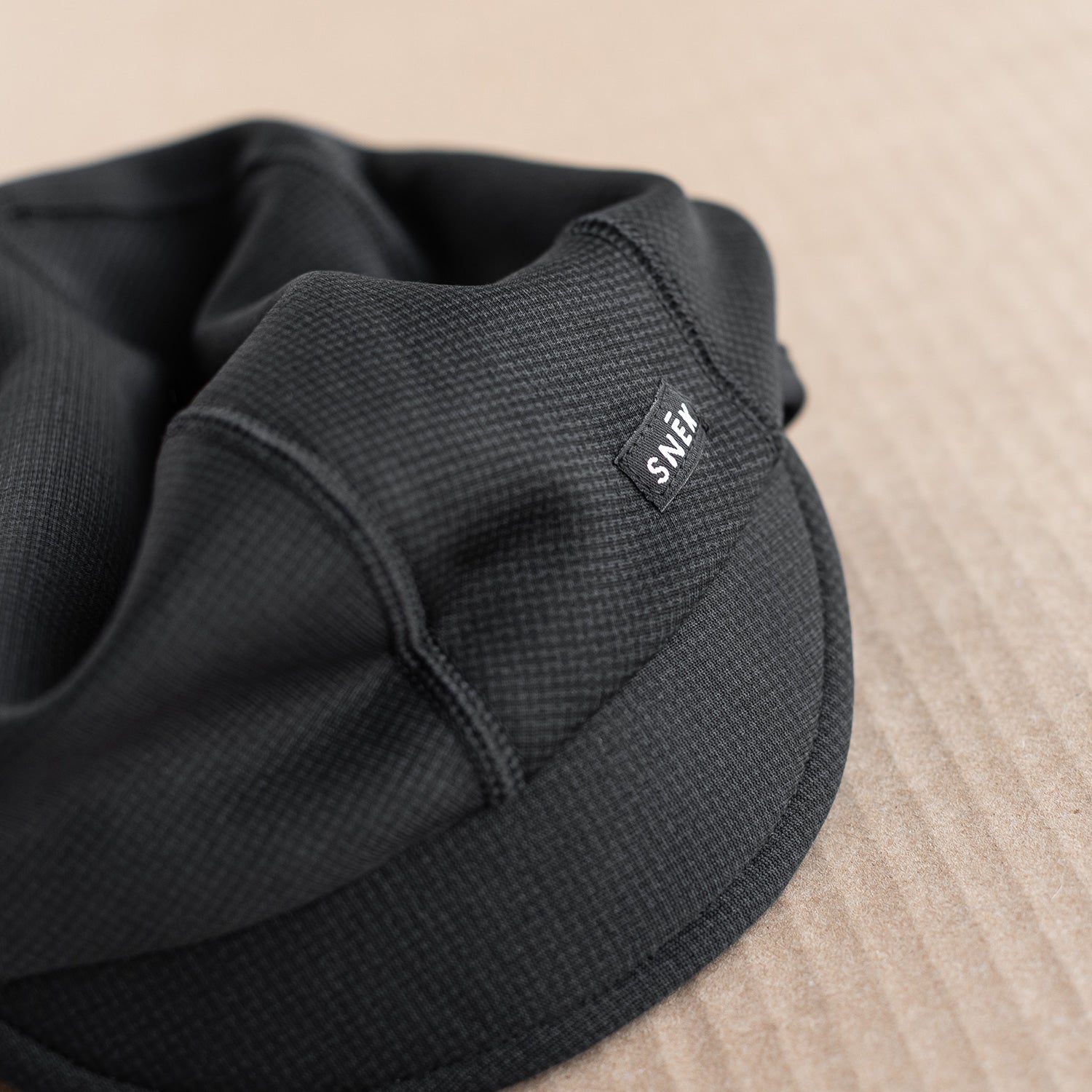snek cycling outer hardface of winter cap detail with snek woven label