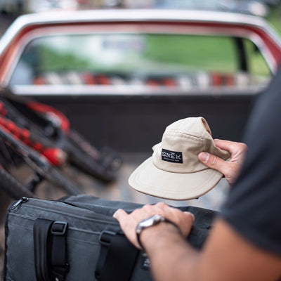 5 panel camper hat being placed in a big cycling lifestyle
