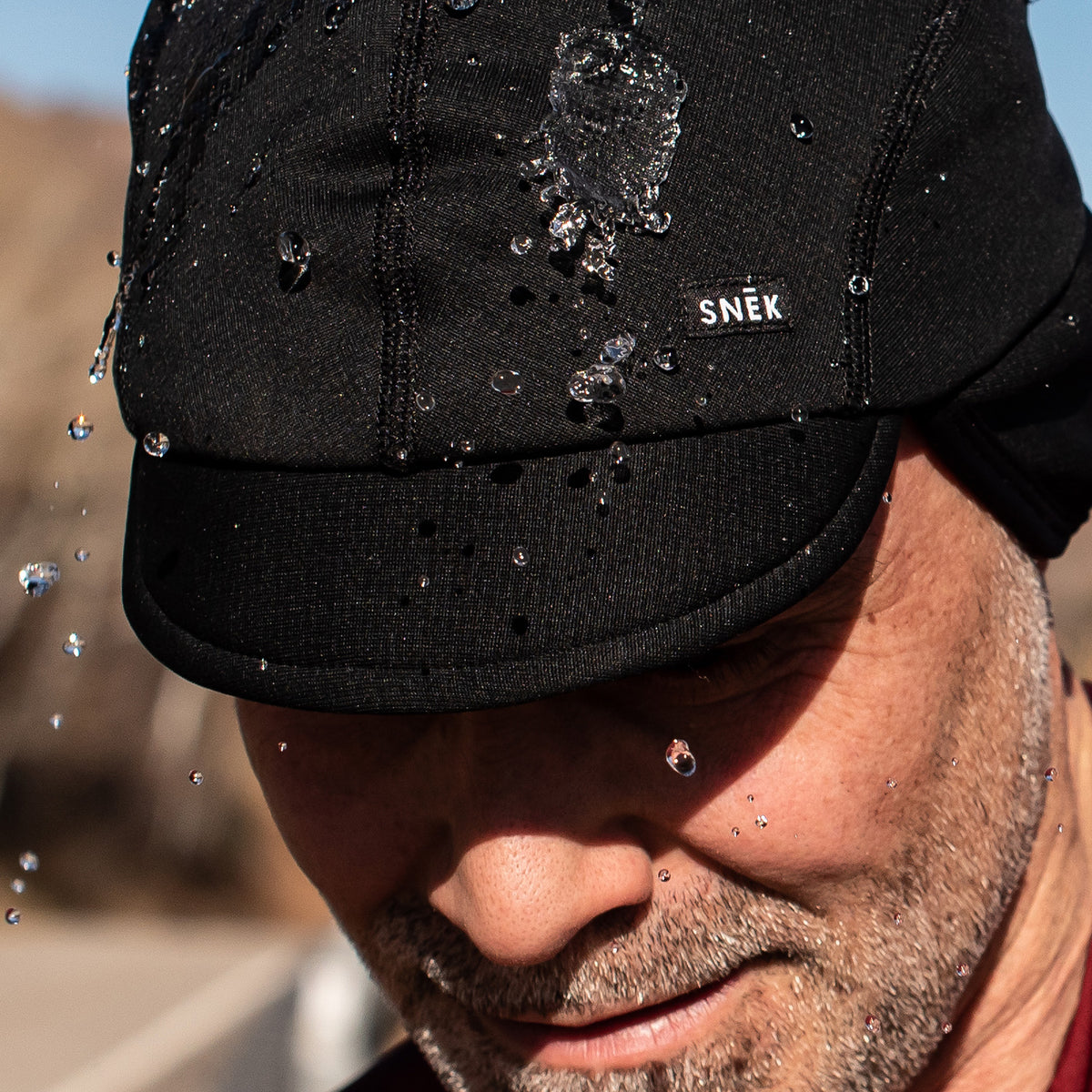 snek cycling polartec hardface winter cap on model showing water repellency