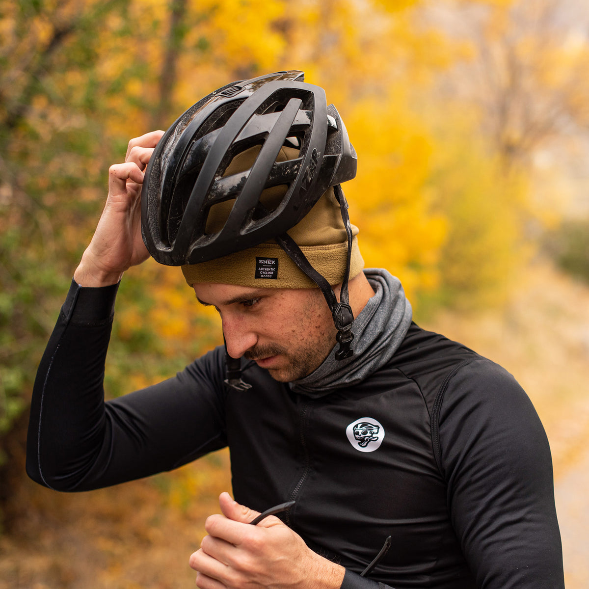 snek cycling hardface fleece beanie outside on model wearing a helmet in utah